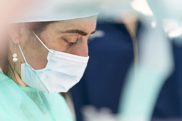 Imagen de una dentista con mascarilla durante una cirugía oral